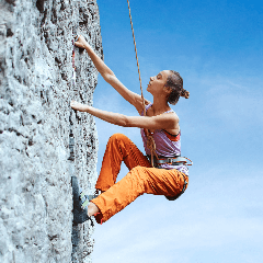 Image of a rock climber ascending a steep cliff face.