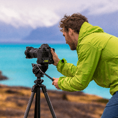 Image of a photographer capturing the landscape with a camera.