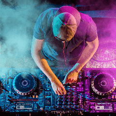 Image of a DJ mixing music at a rave or club event.