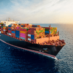 Image of a cargo ship sailing on the water, loaded with containers.