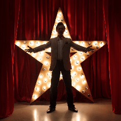 Image of an actor performing on a stage in a theater or venue.